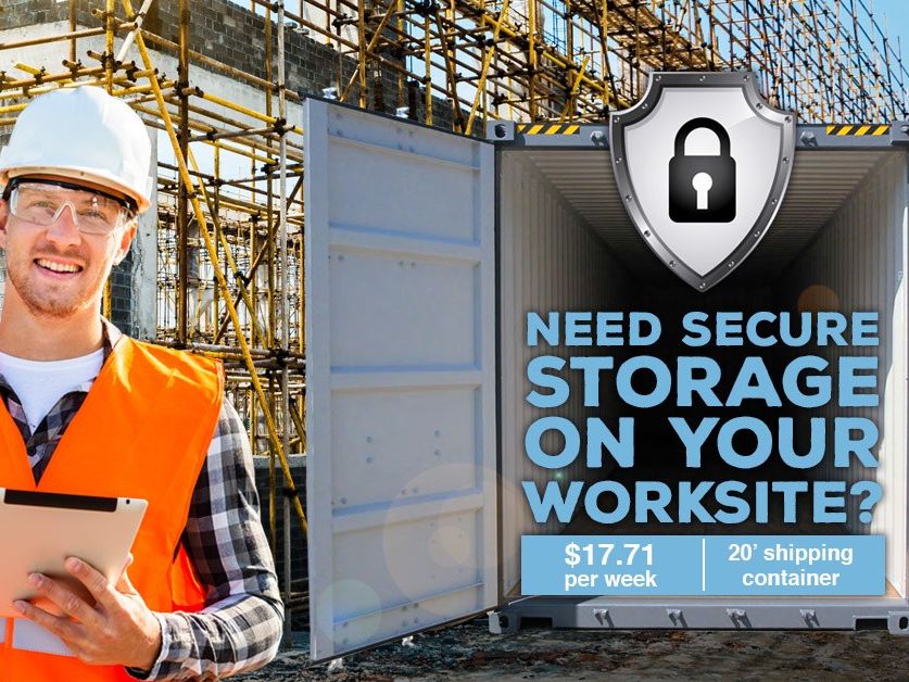 Worker in a hard hat beside an open shipping container on a construction site