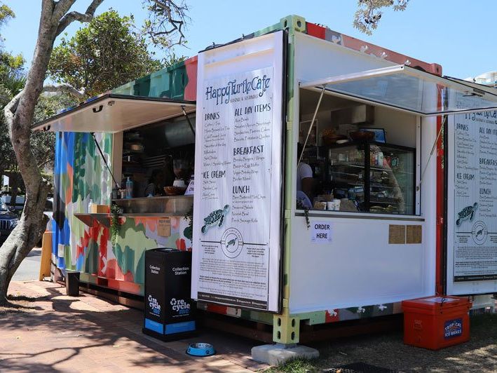 Shipping container converted into the colourful Happy Turtle Cafe with its servery open