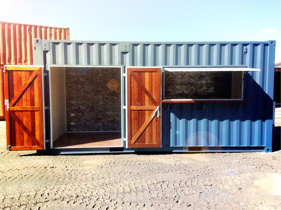 Blue container cafe with timber doors and a serving window open