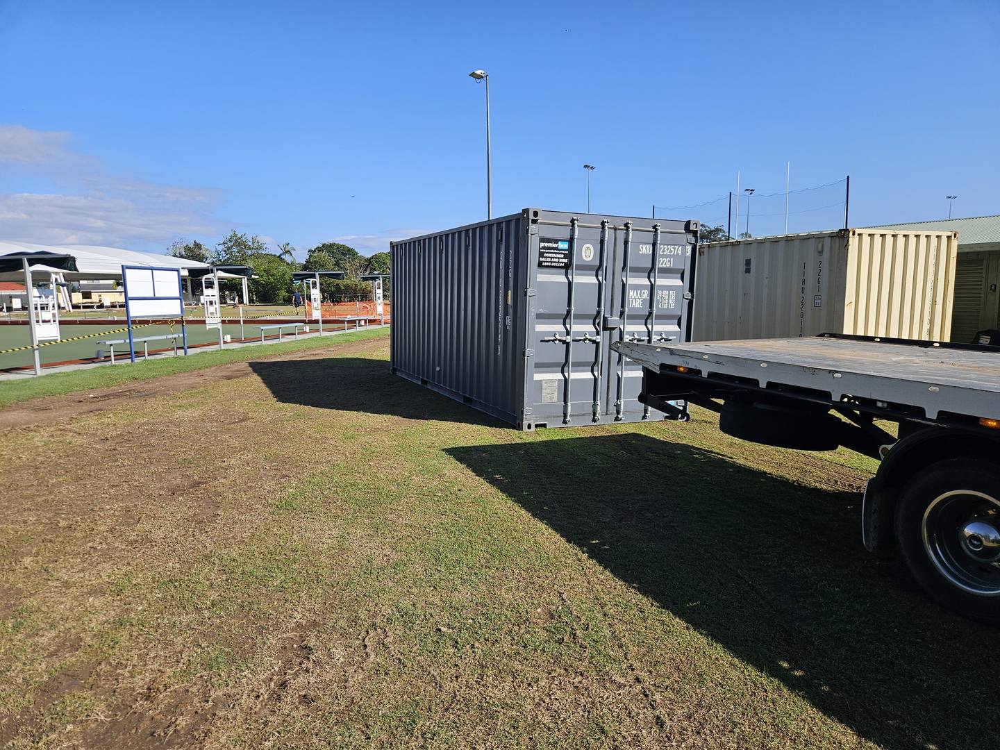 Charcoal hire container on a tilt tray truck on a grassed site