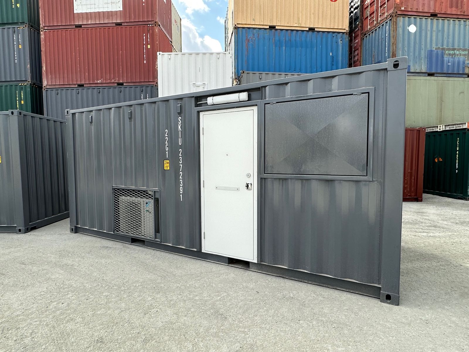 Charcoal container converted into an office with a door and a security screened window