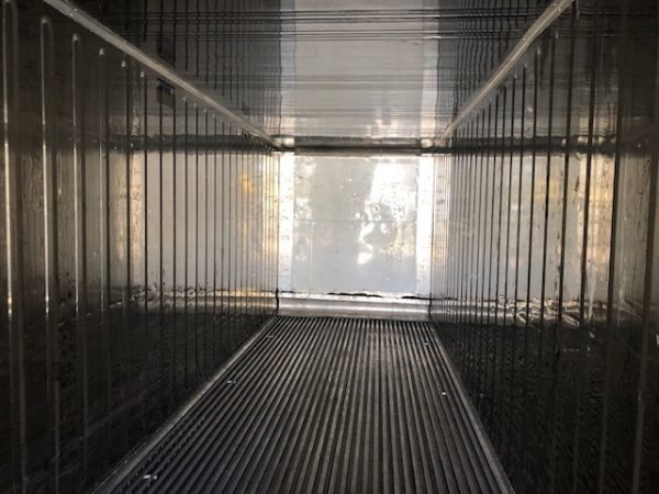 Refrigerated container interior looking down its ribbed floor to the open doors