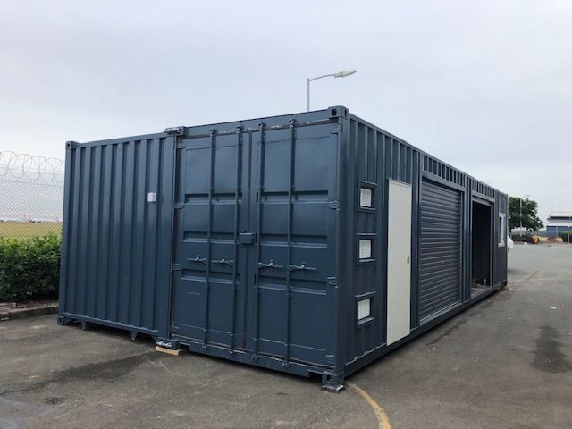 Two joined navy 40ft containers with windows, a PA door and a roller door