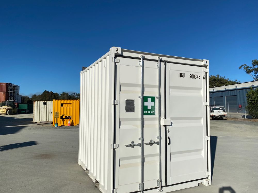 White 10ft container first aid room with a green first aid sign