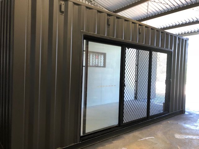 Dark container coffee shop with glazed sliding doors