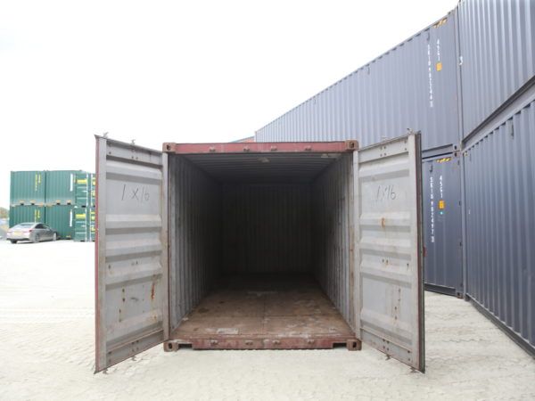 Interior of a used container with doors open, showing a worn timber floor