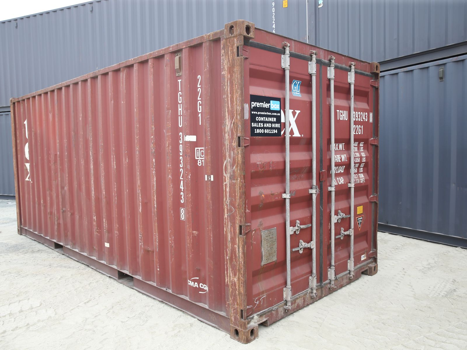 Weathered red 20ft used shipping container in a container yard