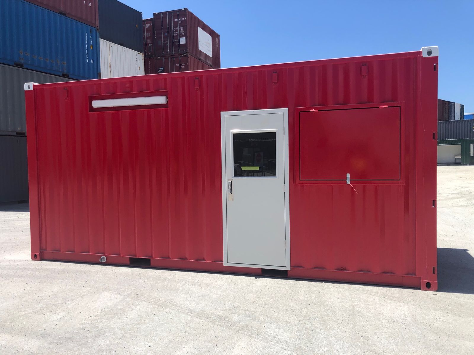 Red container converted into a site hut with a door and window