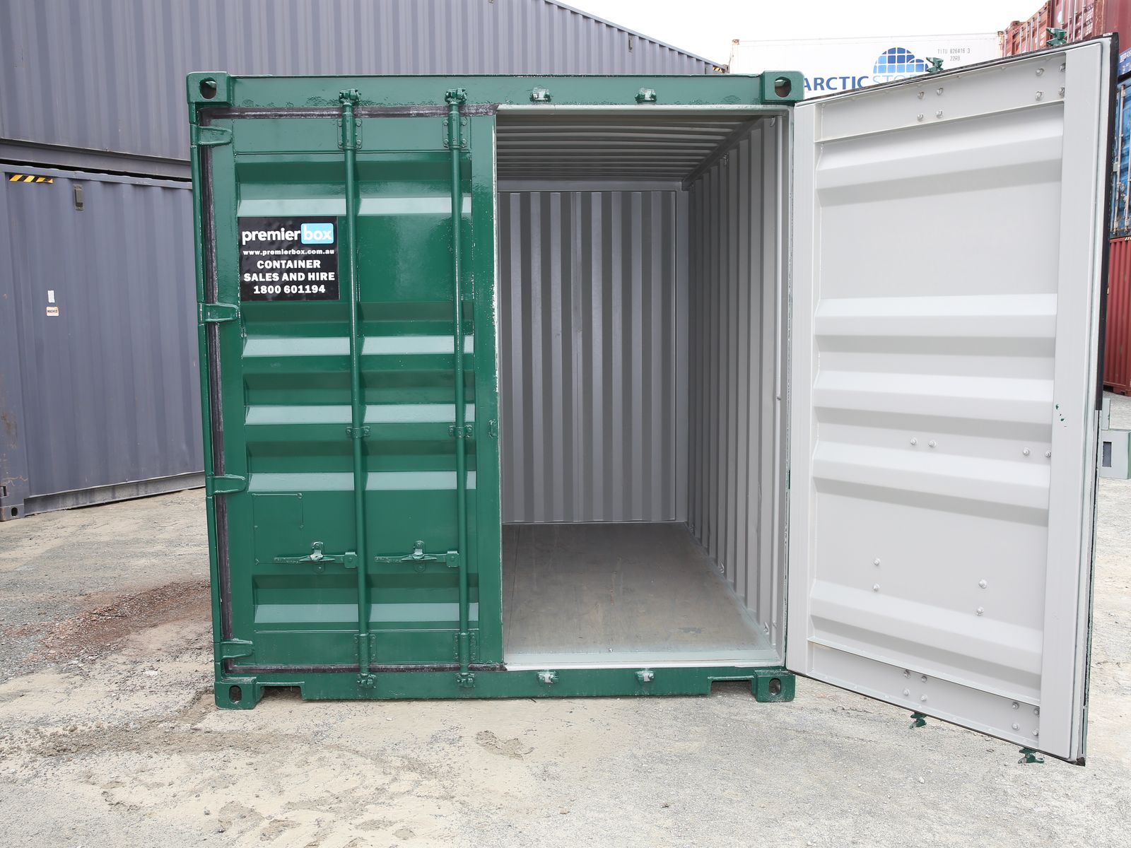 Green premierbox 20ft container with one door open in the yard