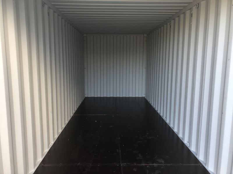 Clean white interior of a hire container with a dark timber floor